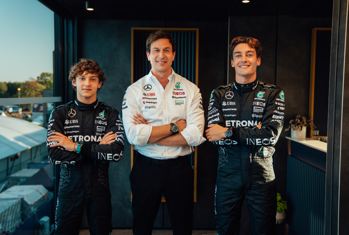 George Russell and Kimi Antonelli in Mercedes F1 gear, with Toto Wolff in the background